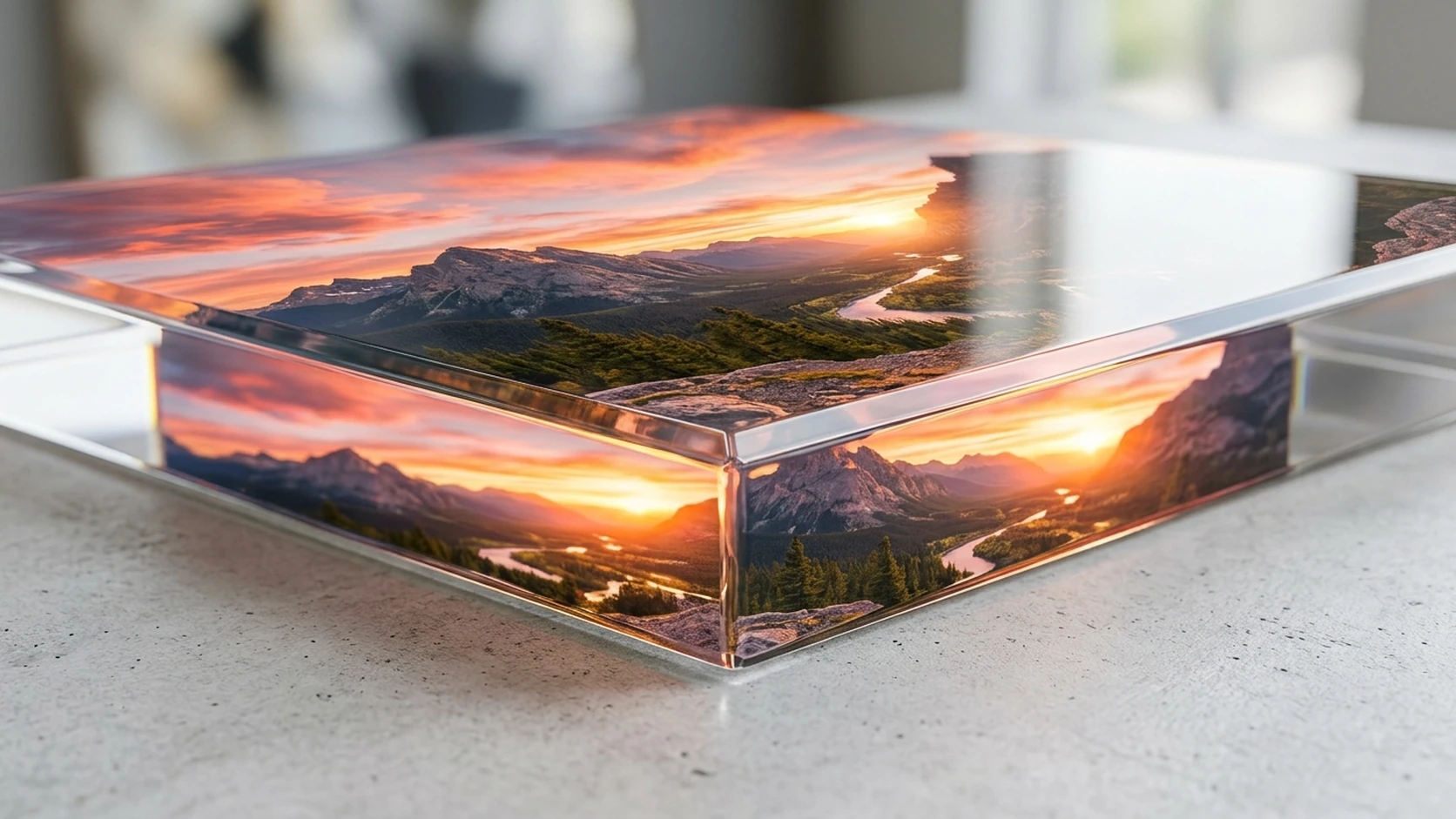 Close-up of a thick acrylic print's clear glossy edge showing a mountain sunset