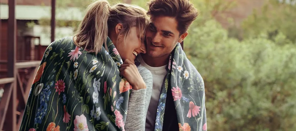 Customized blankets for boyfriends: a couple snuggling in a blanket