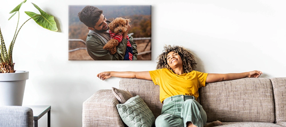 The Best Canvas Prints for Tight Budgets. Young woman relaxing next to her photo canvas print.
