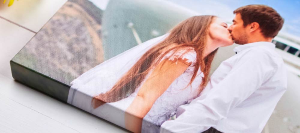 The Pros & Cons of Canvas Printing. Wedding photo canvas print with couple kissing.