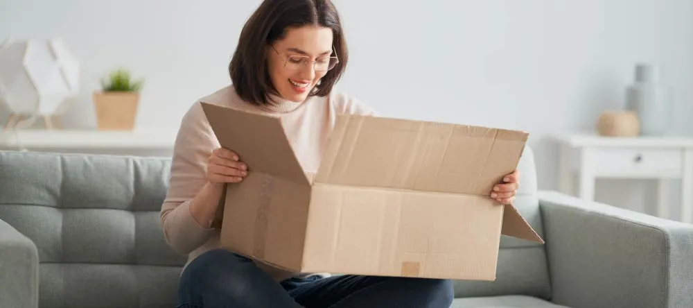 What is the Best Place to Get Canvas Prints on a Budget? Young woman opening her just delivered order. 