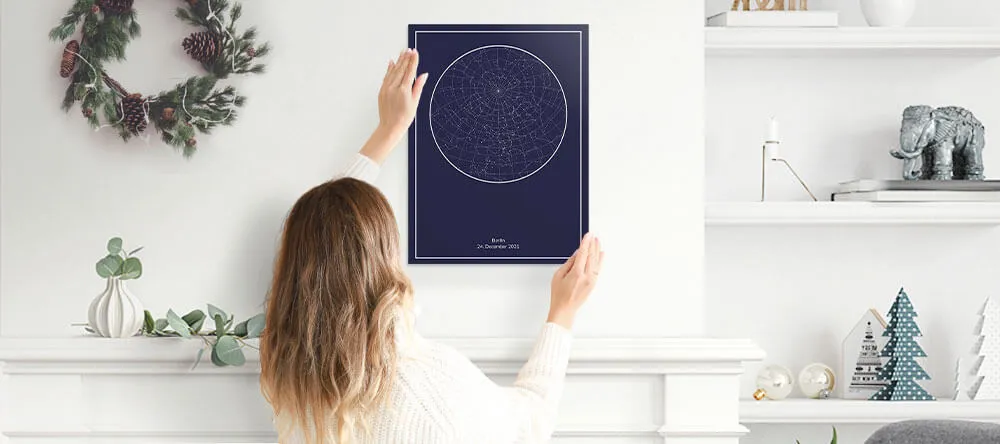 A woman hanging her custom star map print