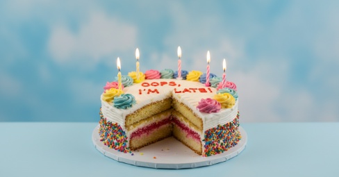 Thoughtful 'Happy Belated Birthday' card with a gift, acknowledging a late but sincere birthday wish