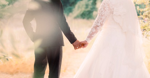Couple holding hands and showing their wedding rings, symbolizing lasting love and wedding card messages