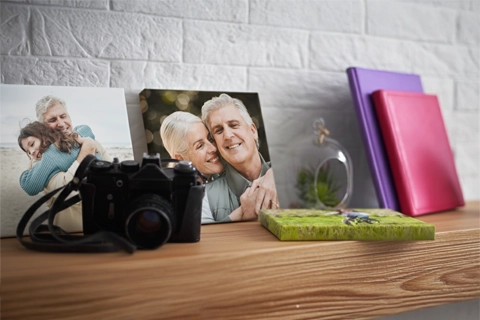 two mini canvas with family portraits on a wooden shelf